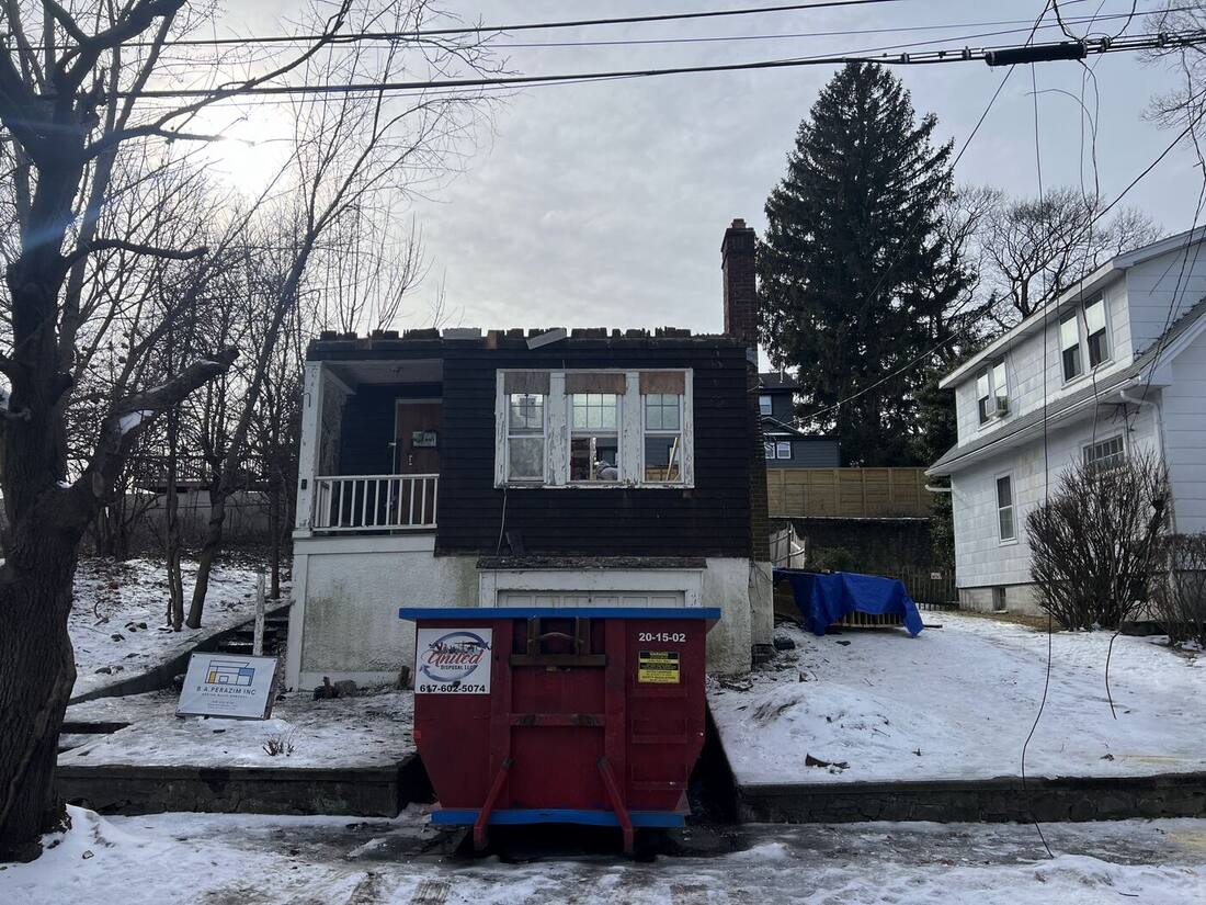 House in winter with dumpster on site, ready for the addition