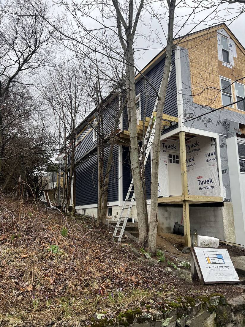 Side elevation with housewrap and navy siding starting