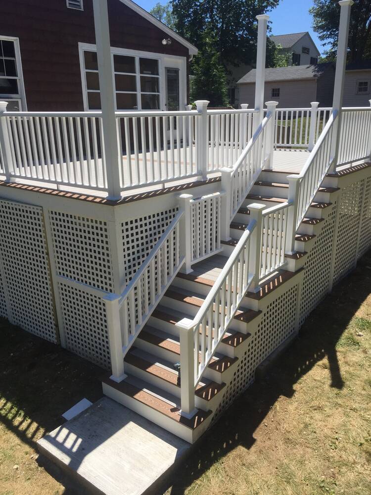 Finished stairs with white railings, two-tone treads and lattice skirting
