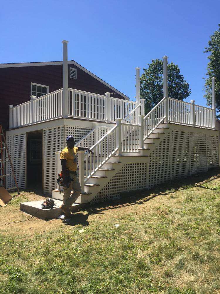 Finished deck and stairs from the yard, with a crew member