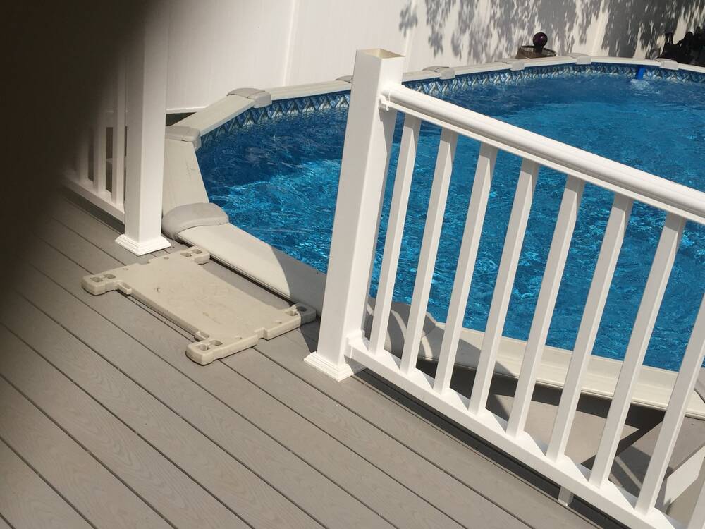 Composite decking and white railing at the pool edge