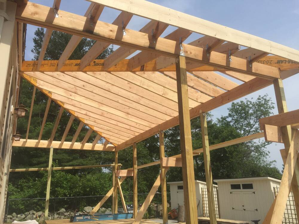 Rafters and LVL beams framing the new covered porch roof