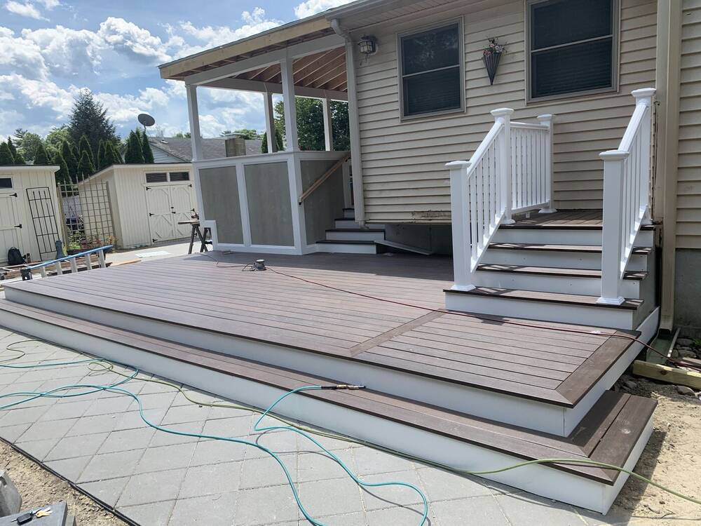 Brown composite deck with picture-frame border and white railings