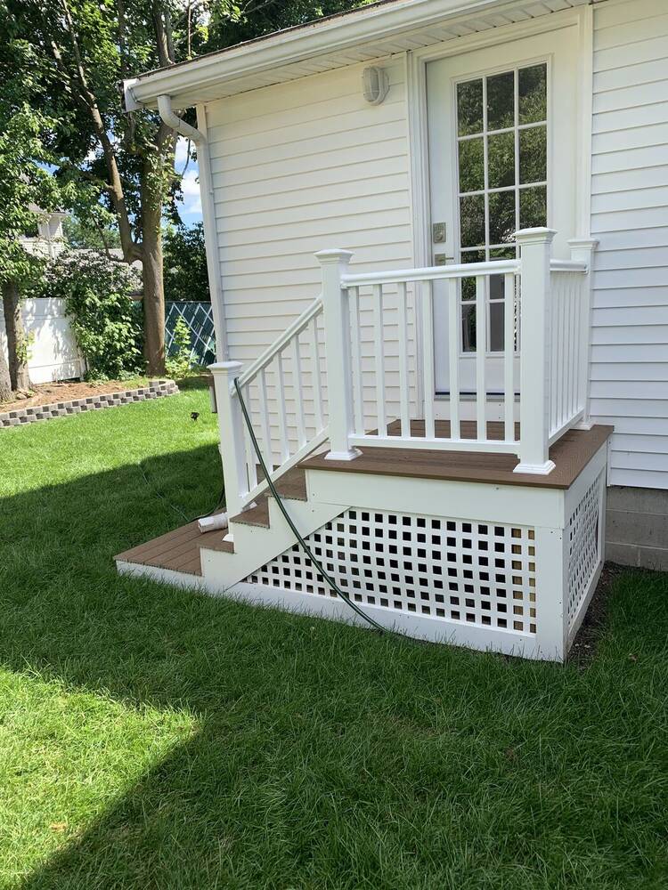 Small entry deck with white railings, composite stairs and lattice skirting
