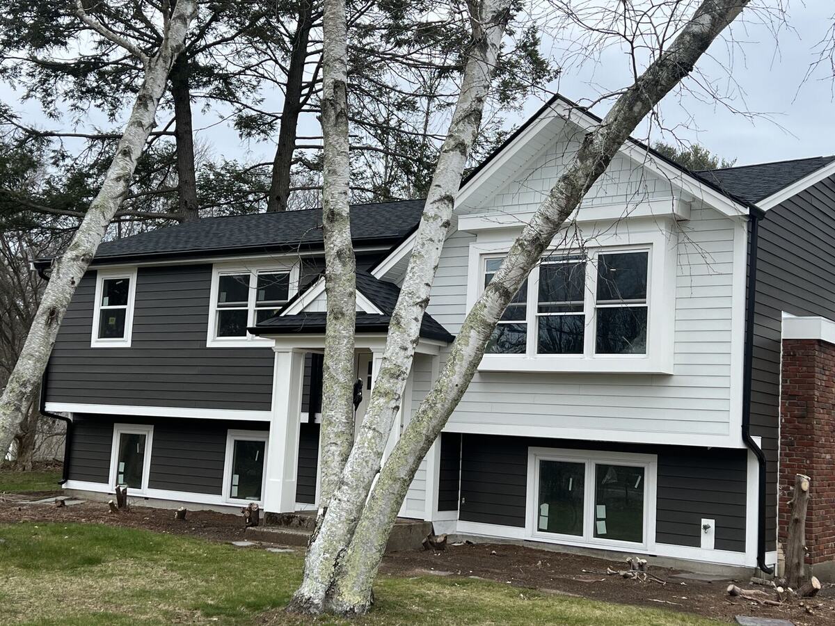 Split-level home with new charcoal and white siding, roof and windows
