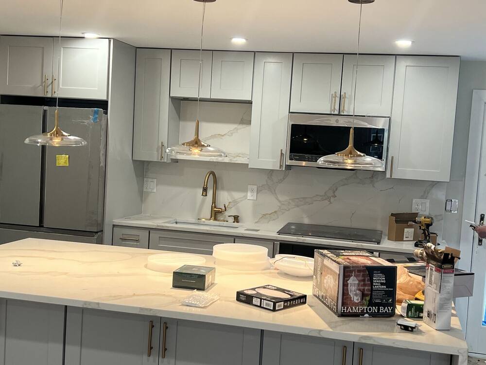 Finished kitchen with brass pendants, quartz counters and stainless appliances