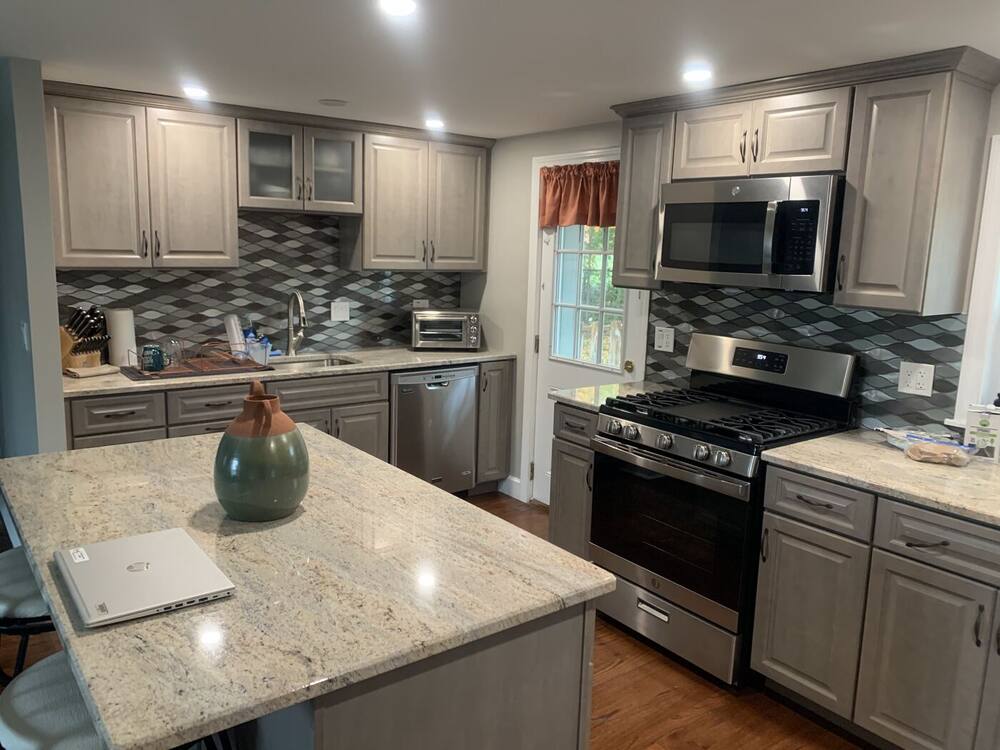Gray cabinets, glass mosaic backsplash and granite island