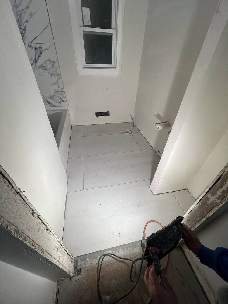 Bathroom stripped and prepared, with the new tub set