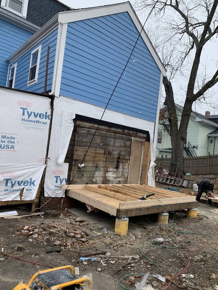 Rear wall being wrapped and sided, with a new deck platform framed