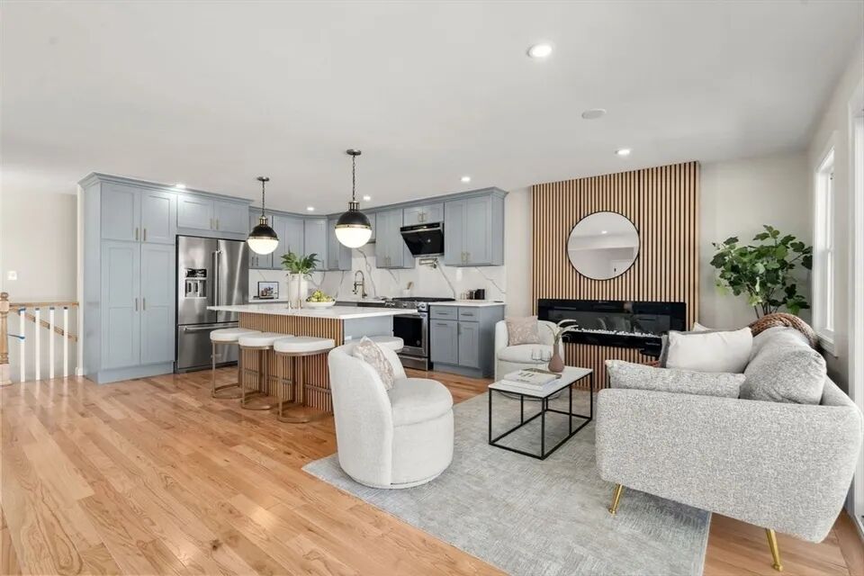 Living room with a wood-slat feature wall and linear electric fireplace beside the kitchen