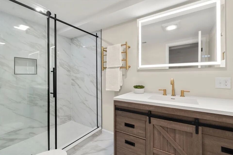 Glass shower, barn-door vanity and lighted mirror