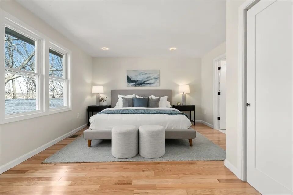 Bright bedroom with new hardwood floors, recessed lights and large windows