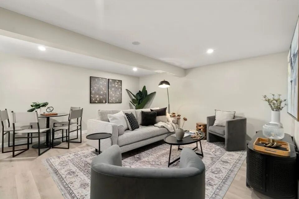 Finished basement living area with recessed lighting and new flooring